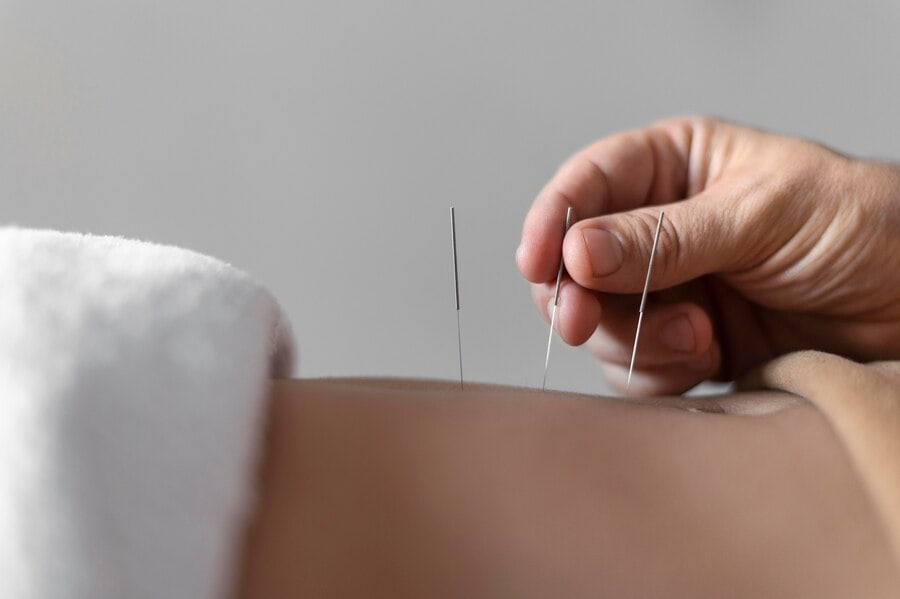 hand holding a needle on the belly